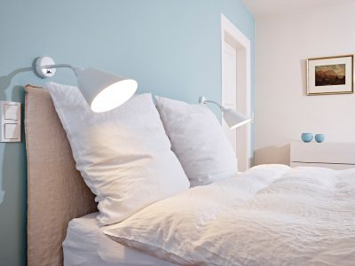Die Wandleuchte Bellevue von Arne Jasobsen bietet perfektes Licht zum Lesen am Bett.