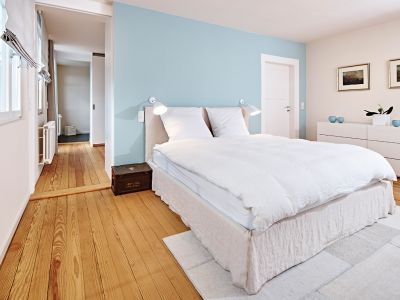 Die ice-blaue Wand, die warmen Textilien und der alte Holzdielenboden bieten dem Bett Ghost von Gervasoni einen stimmungsvollen Rahmen.
